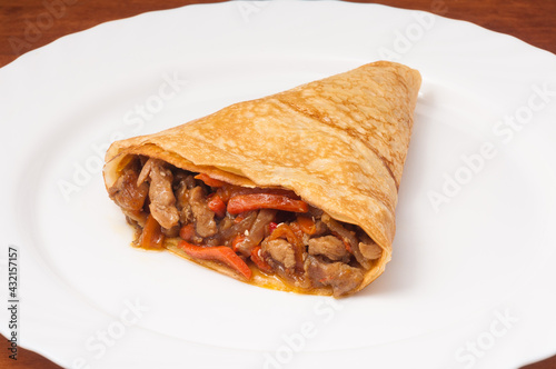 crepe with chicken and vegetables on a white plate