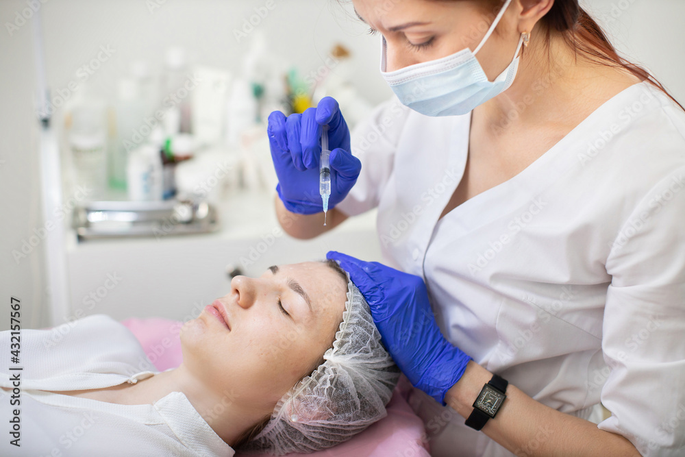 Close up of female doctor beautician, applying cosmetic serum on woman's face at modern cosmetology center. Anti aging and anti wrinkle therapy. Skin care and beauty Close up of female doctor beautician, applying cosmetic serum on woman's face at modern cosmetology center. Anti aging and anti wrinkle therapy. Skin care and beauty