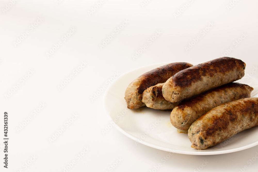 Fried sausage on a white plate on a white plate front view