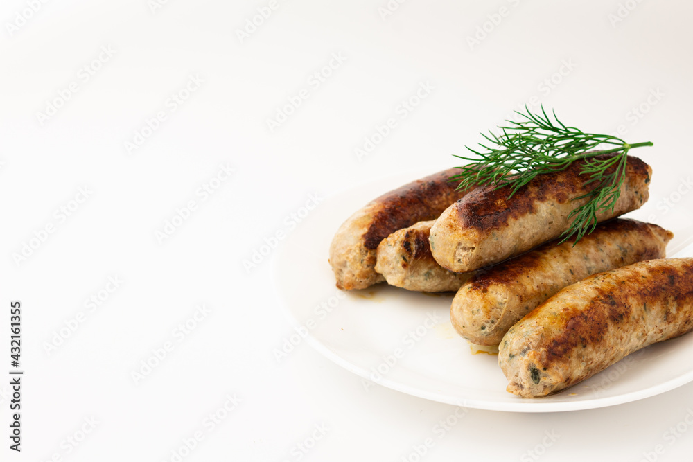 Fried sausage on a white plate on a white plate with herbs Fried sausage on a white plate on a white plate with herbs