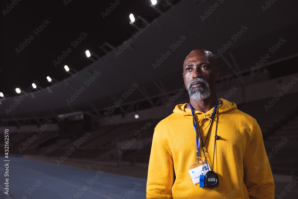 © Wavebreak Media - African american senior male coach standing on the running track at night © Wavebreak Media - African american senior male coach standing on the running track at night