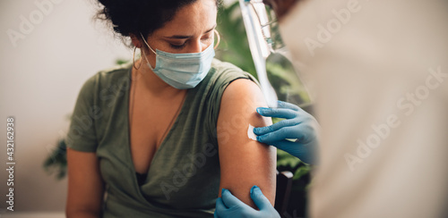 Woman receiving covid vaccine at home photo