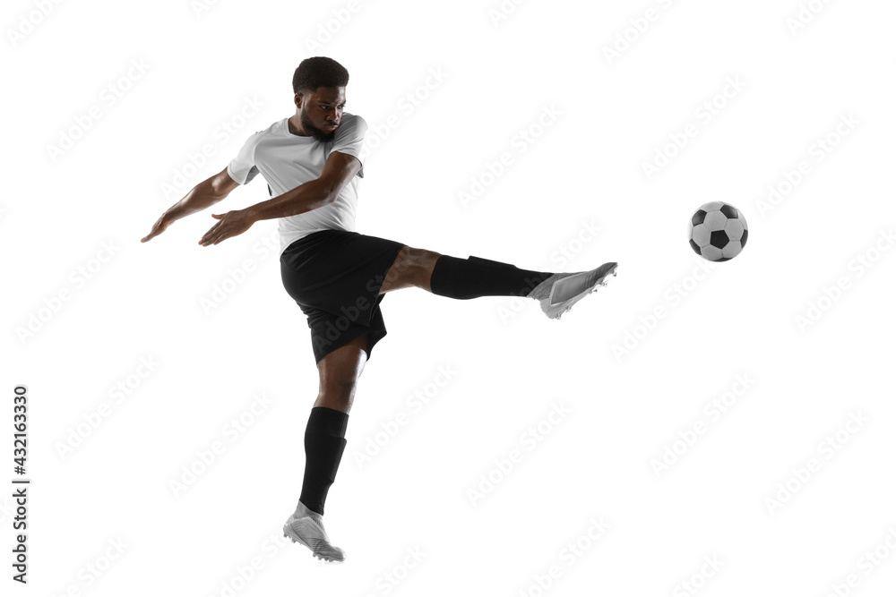 One African man football player training isolated on white background. Concept of sport, movement, energy and dynamic. One African man football player training isolated on white background. Concept of sport, movement, energy and dynamic.