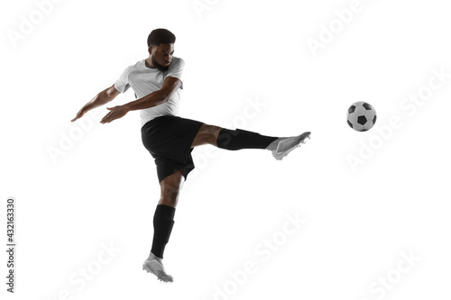 One African man football player training isolated on white background. Concept of sport, movement, energy and dynamic.