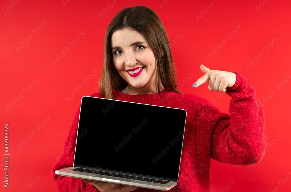 Close-up portrait photo of beautiful happy smiling girl with long hair wearing red hoodie holding computer laptop Close-up portrait photo of beautiful happy smiling girl with long hair wearing red hoodie holding computer laptop