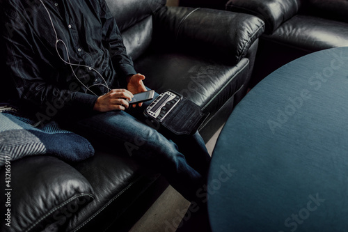 Man sitting on sofa and using Braille keyboard photo