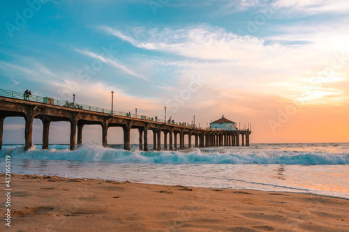 Manhattan beach pier at sunset, orange-pink sky with bright colors, beautiful landscape with ocean and sand © KseniaJoyg