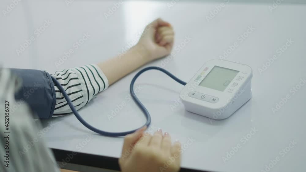 Close-up woman Self monitoring , analysing, check blood pressure. Healthcare equipment, devices at home. Spanish woman measure blood pressure in BP watch device. Close-up woman Self monitoring , analysing, check blood pressure. Healthcare equipment, devices at home. Spanish woman measure blood pressure in BP watch device.