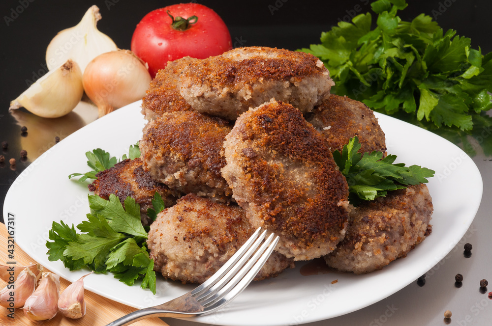 fried meat cutlets decorated with vegetables and herbs