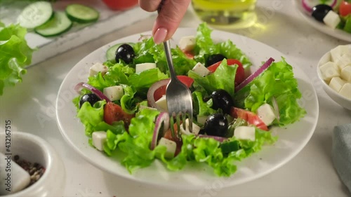 Greek salad of fresh cucumber, tomato, lettuce, red onion, feta cheese and olives with olive oil.