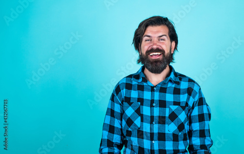 mature barber on blue background. masculinity and charisma. casual fashion style. modern looking bearded hipster. hairdresser concept. brutal handsome man with moustache. place for copy space