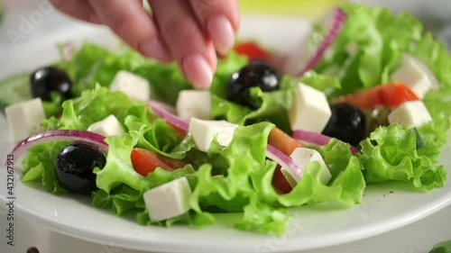 Greek salad of fresh cucumber, tomato, lettuce, red onion, feta cheese and olives with olive oil.