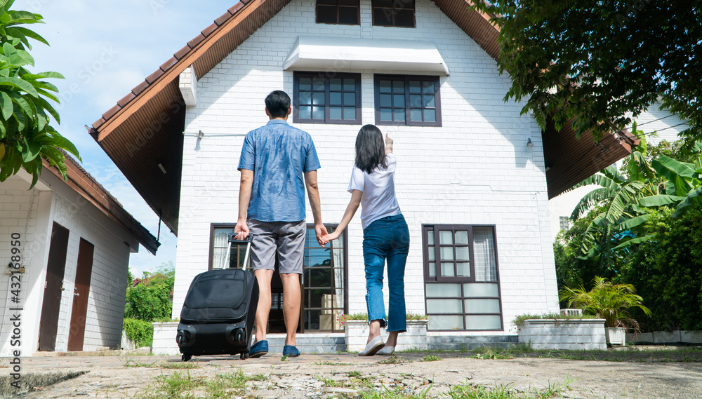 Happy couple in front of the New Home On Moving In Day, and start a new life family. Concept of homeowner and relocation Happy couple in front of the New Home On Moving In Day, and start a new life family. Concept of homeowner and relocation