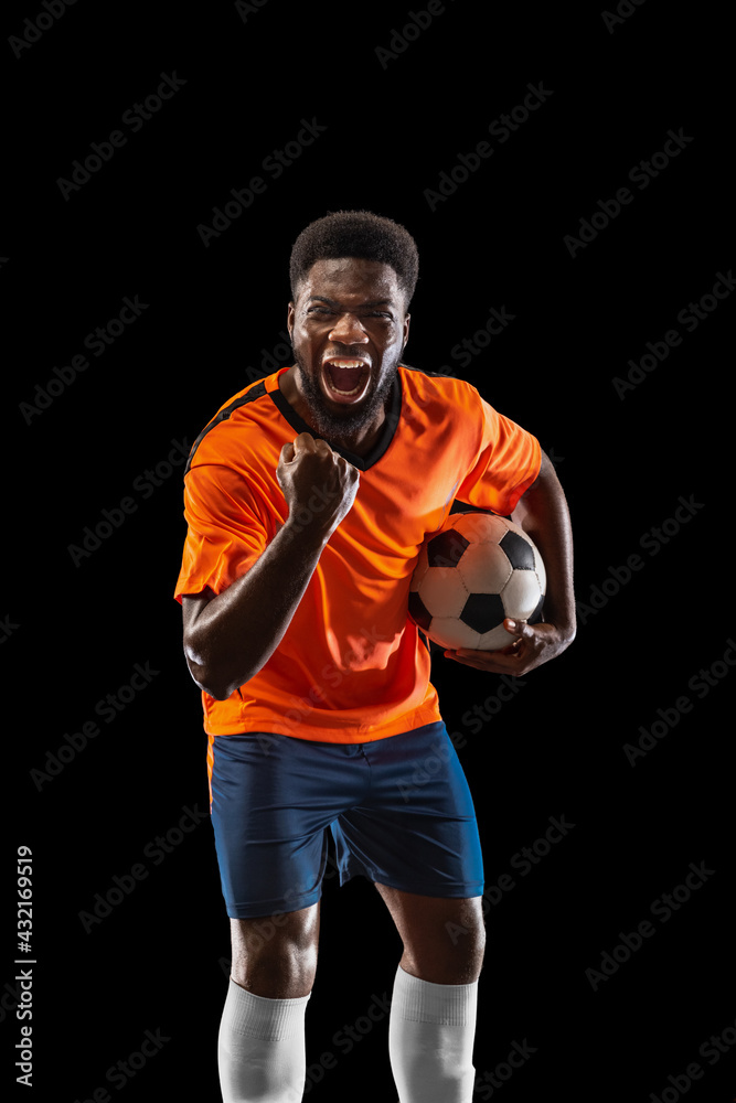 Portrait of young African soccer player posing isolated on black background. Concept of sport. Portrait of young African soccer player posing isolated on black background. Concept of sport.