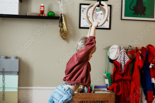 Boy hanging on gymnastic rings photo