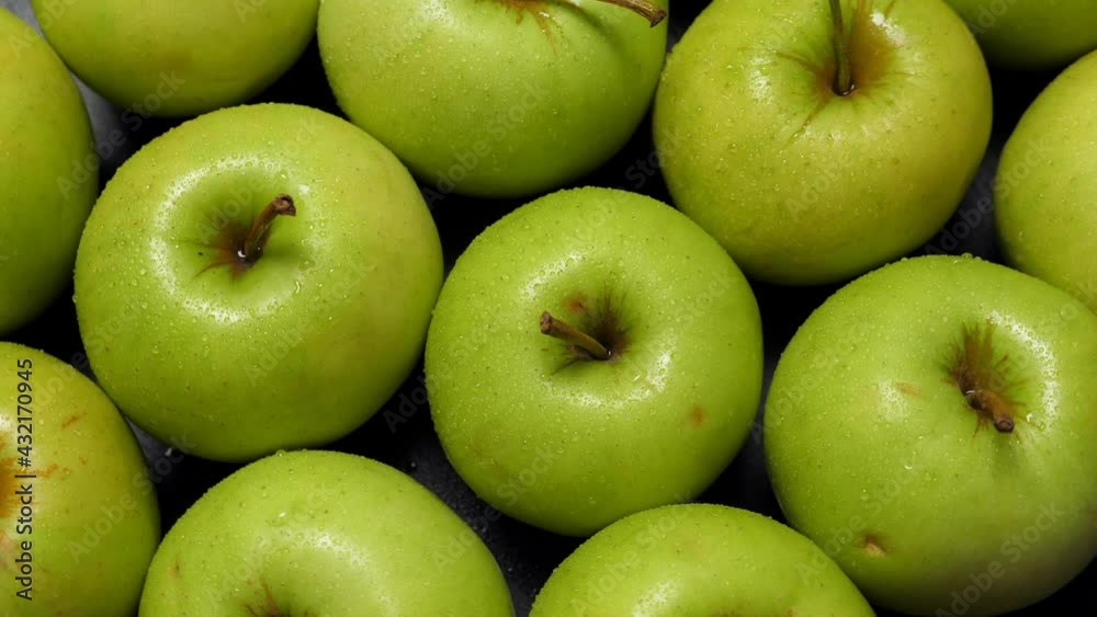 A lot of green apples rotating, closeup. Fruits background A lot of green apples rotating, closeup. Fruits background