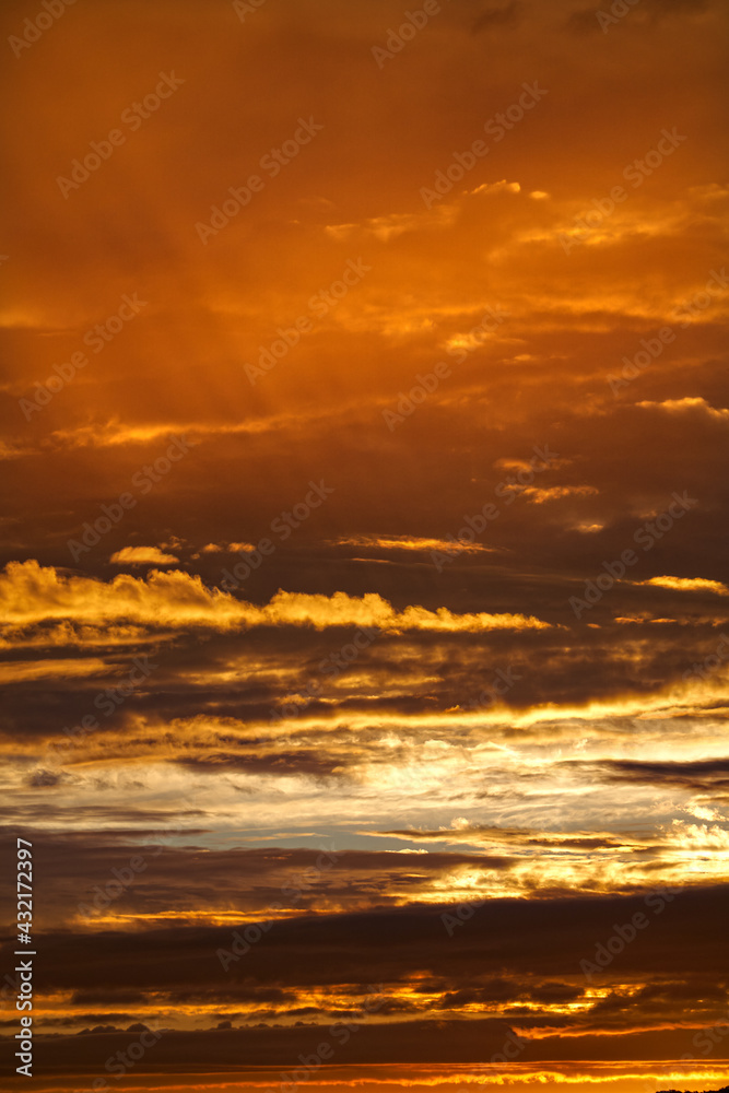 Golden sunset with clouds in the sky; color photo.