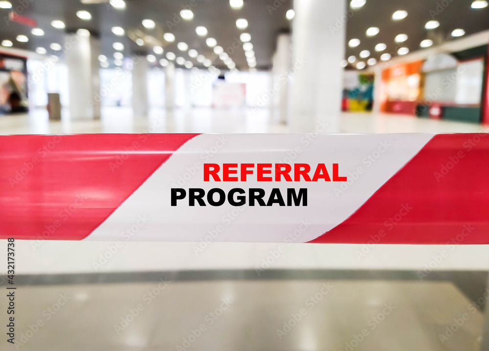 The concept of a referral program on a white-red ribbon. Referral program in modern closed business The concept of a referral program on a white-red ribbon. Referral program in modern closed business