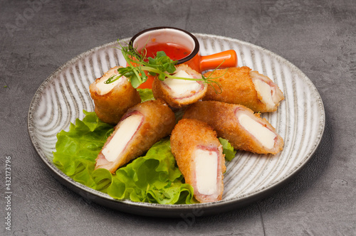 deep-fried ham and cheese rolls with hot sauce
