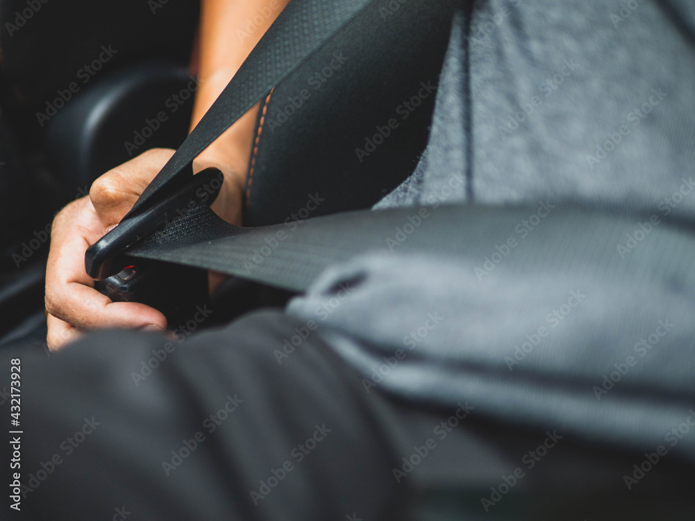 The Man fastening seat belt in the car, safety concept. Safe driving in the journey concept.