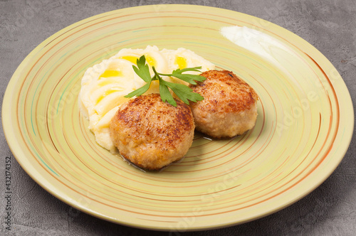 puree with butter and chicken cutlets decorated with a parsley leaf