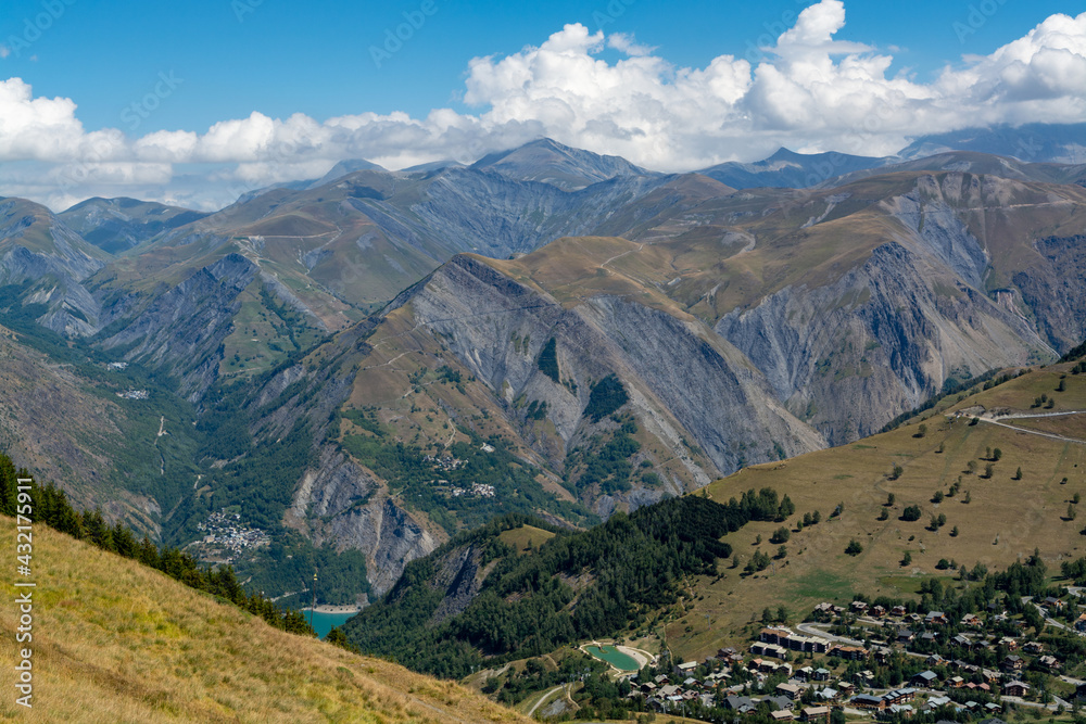 Hiking near ski station Les deux Alpes and view on Alpine mountains peaks in summer, Isere, France