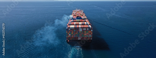 Aerial drone ultra wide photo above huge colourful container carrier vessel cruising deep blue open ocean sea photo