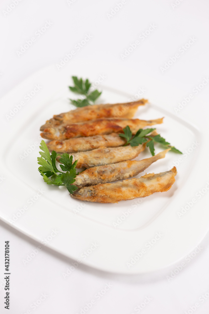 Fried crispy capelin on a white plate Fried crispy capelin on a white plate