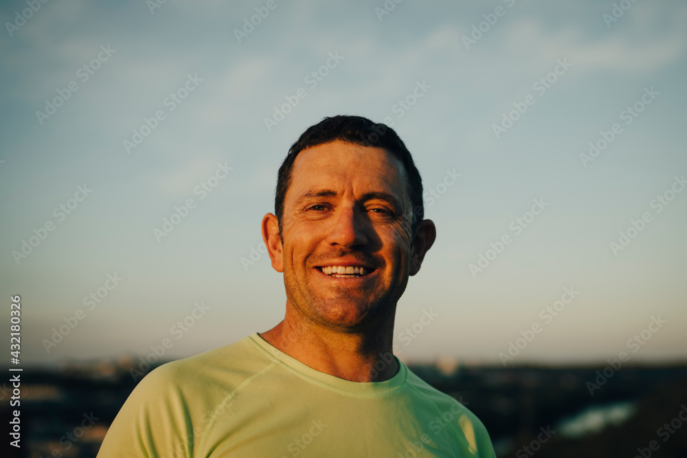 Portrait of smiling sportsman against sky during sunset Portrait of smiling sportsman against sky during sunset