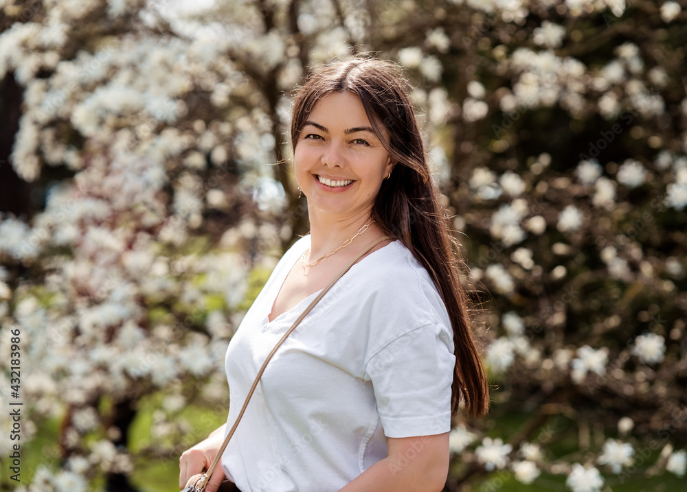 Outdoor portrait of happy beautiful 40 years old woman smiling looking at camera in spring blooming park. Outdoor portrait of happy beautiful 40 years old woman smiling looking at camera in spring blooming park.