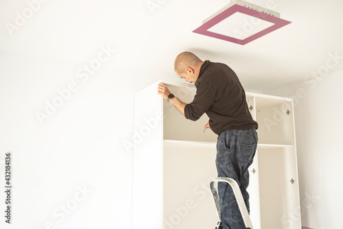 handyman man assembling a closet in a moving house