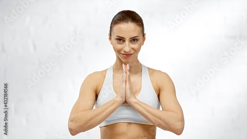 Smiling sportswoman showing paying hands at home.