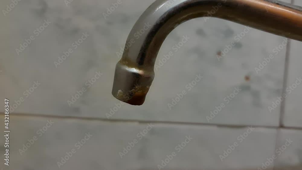 Faucet with rusty water. Water scarcity in the close-up Faucet with rusty water. Water scarcity in the close-up