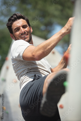 young man exercising at ioutdoor climbing wall