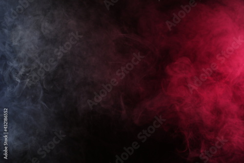 Artificial smoke in white-red light on a black background