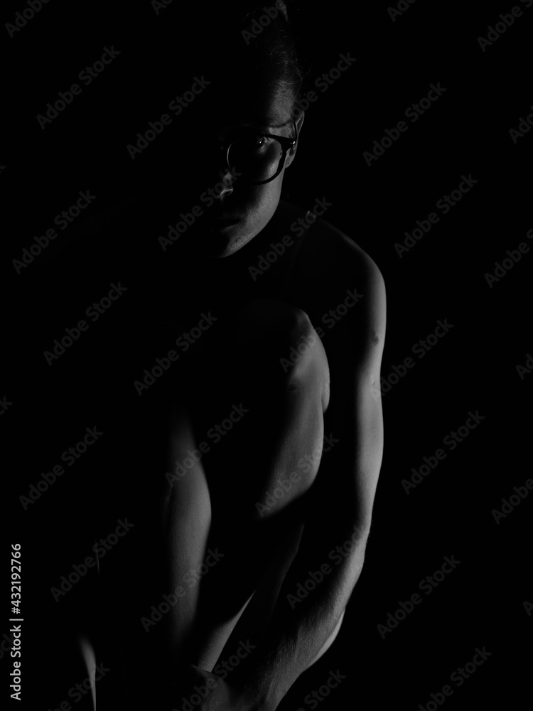 Naked woman in yoga pose on black isolated background with artificial professional lighting without face Naked woman in yoga pose on black isolated background with artificial professional lighting without face