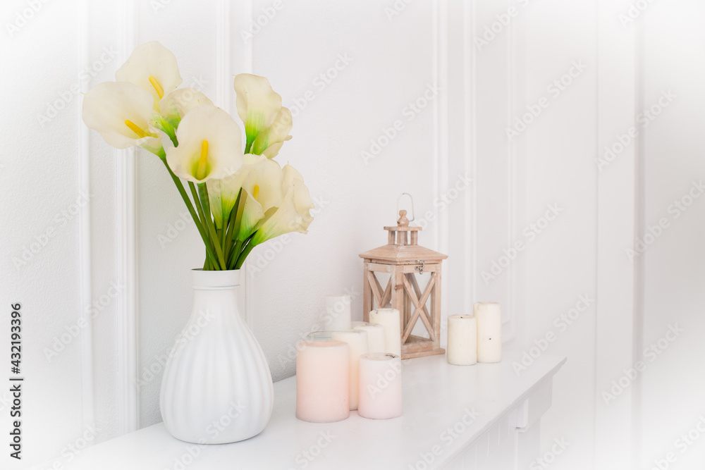 Flowers in a vase and candles in the interior..