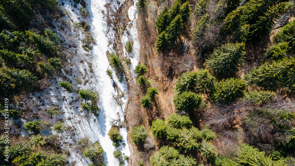 Beautiful drone view of Small puddle of melted white snow in the warm spring sun in the European mountains Beautiful drone view of Small puddle of melted white snow in the warm spring sun in the European mountains