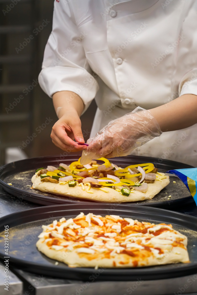 Chefs hands in gloves and preparing  making pizza at kitchen.