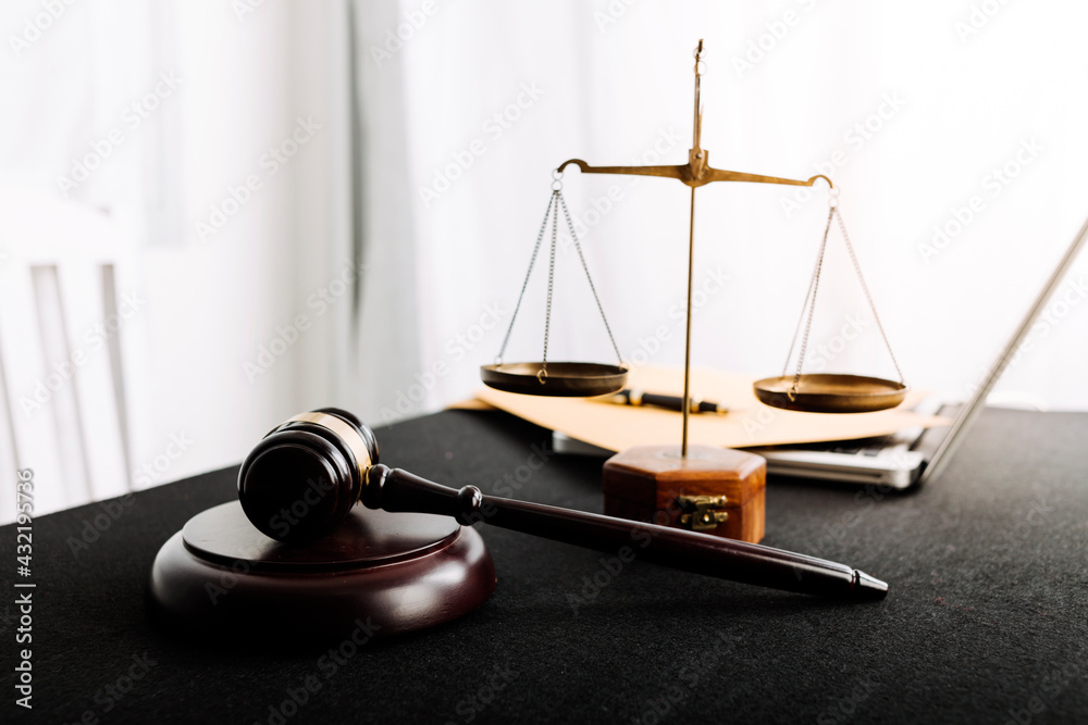 Business and lawyers discussing contract papers with brass scale on desk in office. Law, legal services, advice, justice and law concept picture with film grain effect Business and lawyers discussing contract papers with brass scale on desk in office. Law, legal services, advice, justice and law concept picture with film grain effect
