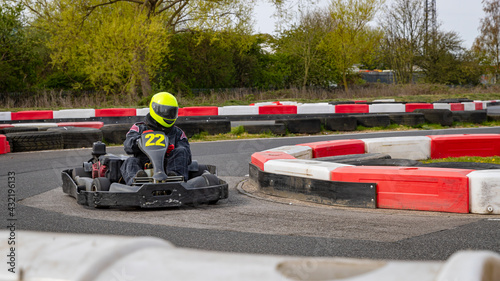 A panning shot of a racing kart as it circuits a track.