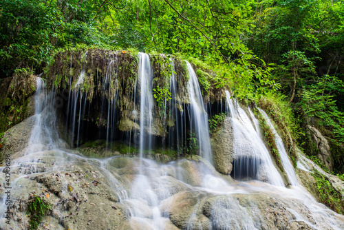 Waterfall and blue emerald water color in Erawan national park. Erawan Waterfall, Beautiful nature rock waterfall steps in tropical rainforest at Kanchanaburi province, Thailand © cattyphoto