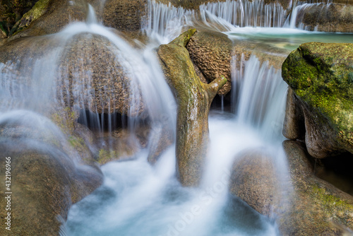 Waterfall and blue emerald water color in Erawan national park. Erawan Waterfall  Beautiful nature rock waterfall steps in tropical rainforest at Kanchanaburi province  Thailand