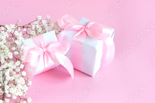 Gift box and a bouquet of blooming gypsophila on a pink background. Mother's day holiday concept. Copy space. © Ekaterina Petrukhan