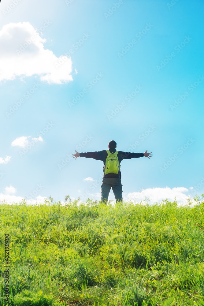 Man with raised hands celebrating at the top of the hill - tourist enjoying freedom on the hill Man with raised hands celebrating at the top of the hill - tourist enjoying freedom on the hill