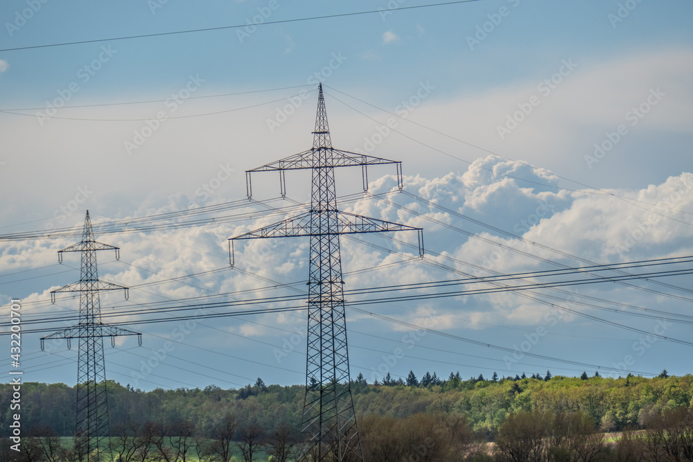 Strommasten einer Überlandleitung vor dunklem Wolkenhimmel Strommasten einer Überlandleitung vor dunklem Wolkenhimmel