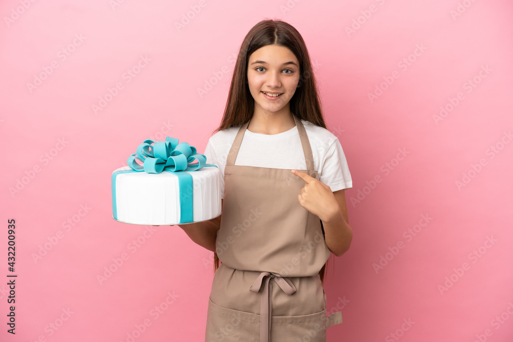 Little girl with a big cake over isolated pink background with surprise facial expression Little girl with a big cake over isolated pink background with surprise facial expression