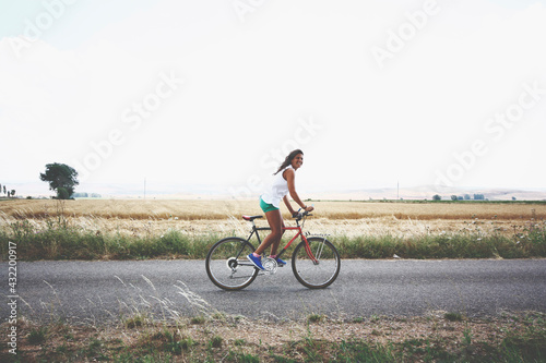 woman traveler enjoying for view of rice field. Spanish lady tourist riding a bicycle and looking for view of nature on holiday.