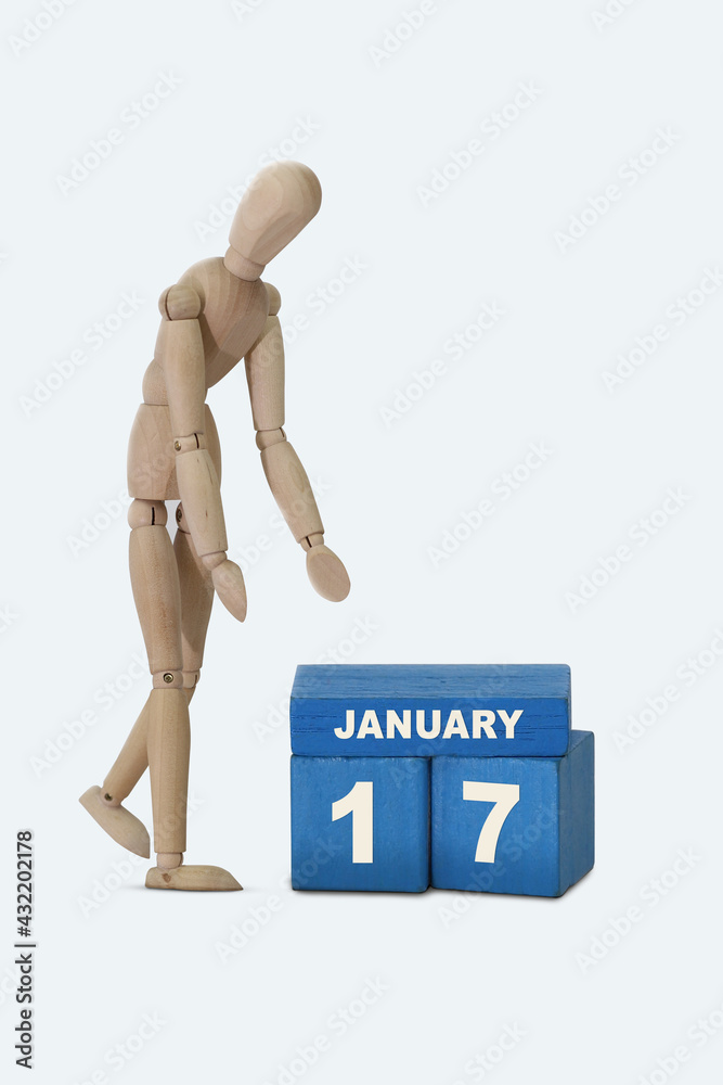 day of the month 17 January calendar . A calendar date on blue cubes and a wooden man standing next to it. White background day of the month 17 January calendar . A calendar date on blue cubes and a wooden man standing next to it. White background