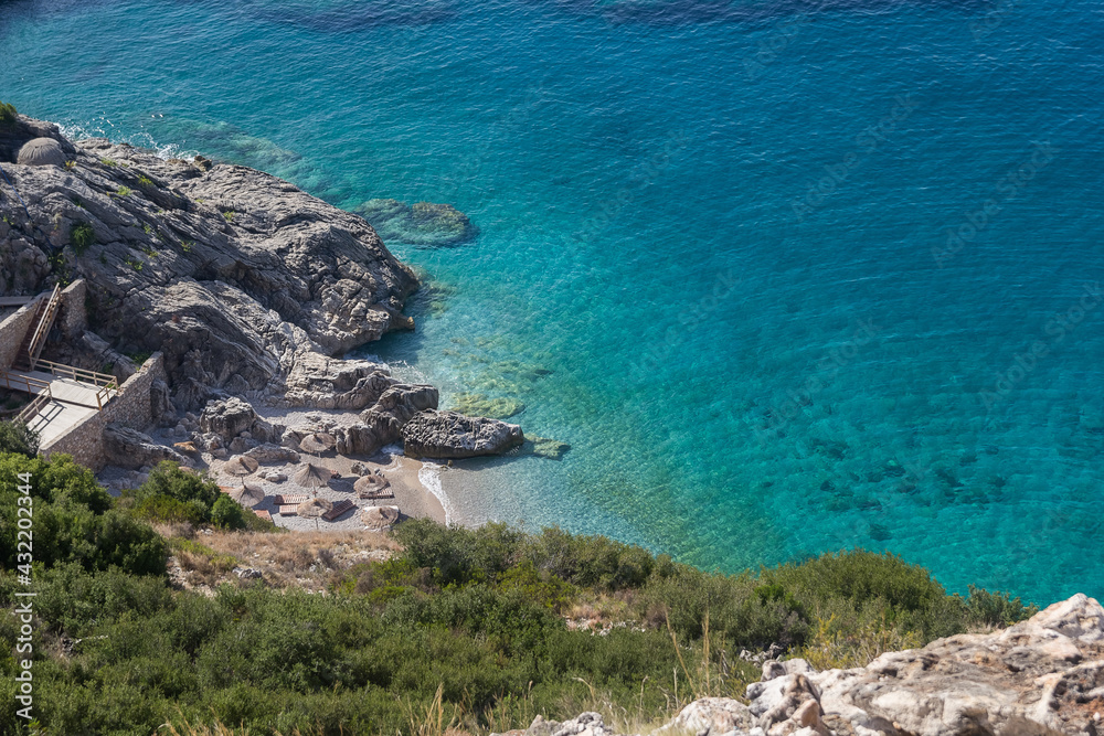 Small beach among rocks and turquoise sea, Albania. Travel and vacation theme, beautiful nature